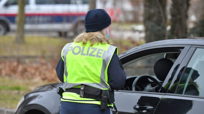 Polizistin steht an Auto