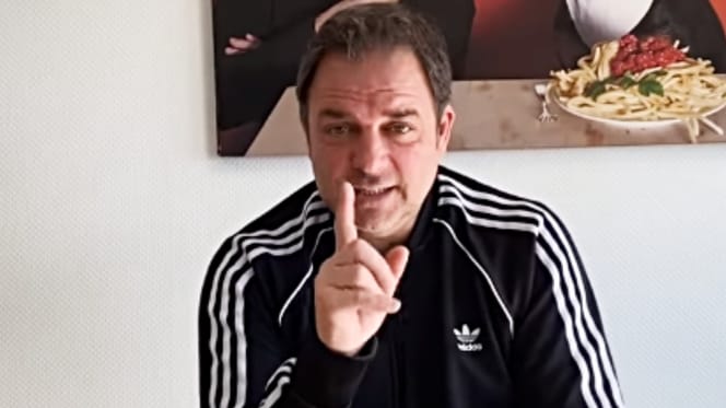 Rütter sitzend mit erhobenem Zeigefinger