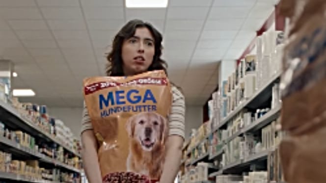 Ratlose Frau mit Hundefutter-Sack im Supermarkt
