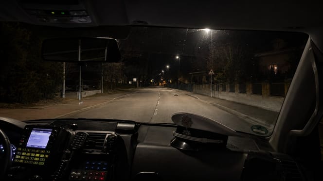 Blick aus Polizeiauto auf dunkle Straße