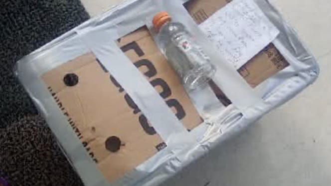 Wasserflasche und Notiz auf dem Karton