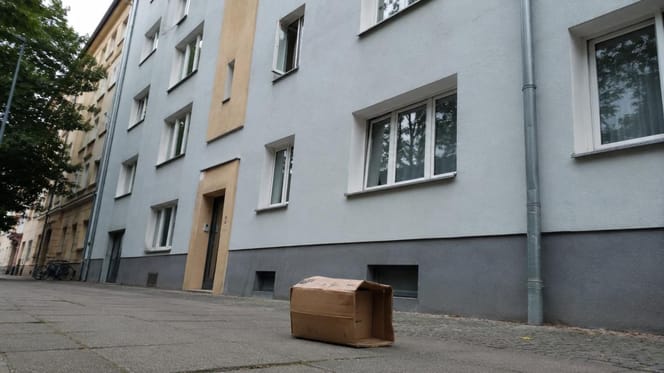 Karton steht auf einem Gehweg