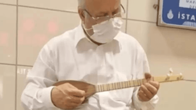 Street cat sleeping on musician's instrument case in underground station