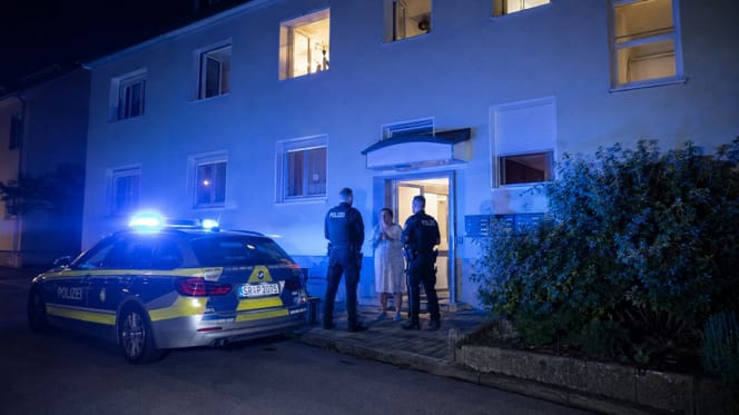 Polizei nachts vor einem Mehrfamilienhaus
