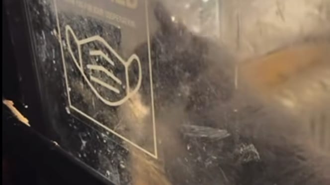 Une ombre dans la vitrine d'un pressing abandonné