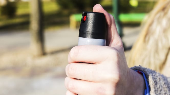 Weibliche Hand mit Pfefferspray