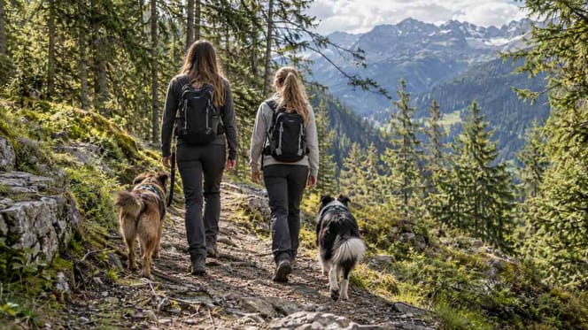 Zwei Mädchen mit Hunden in den Alpen