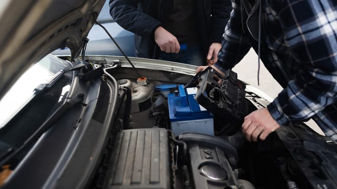 Zwei Männer schauen in einen Auto-Motorraum