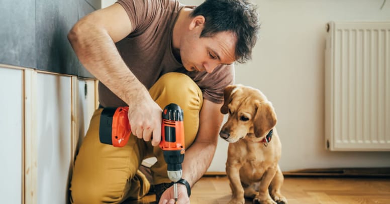 uomo fa lavori in casa con cane