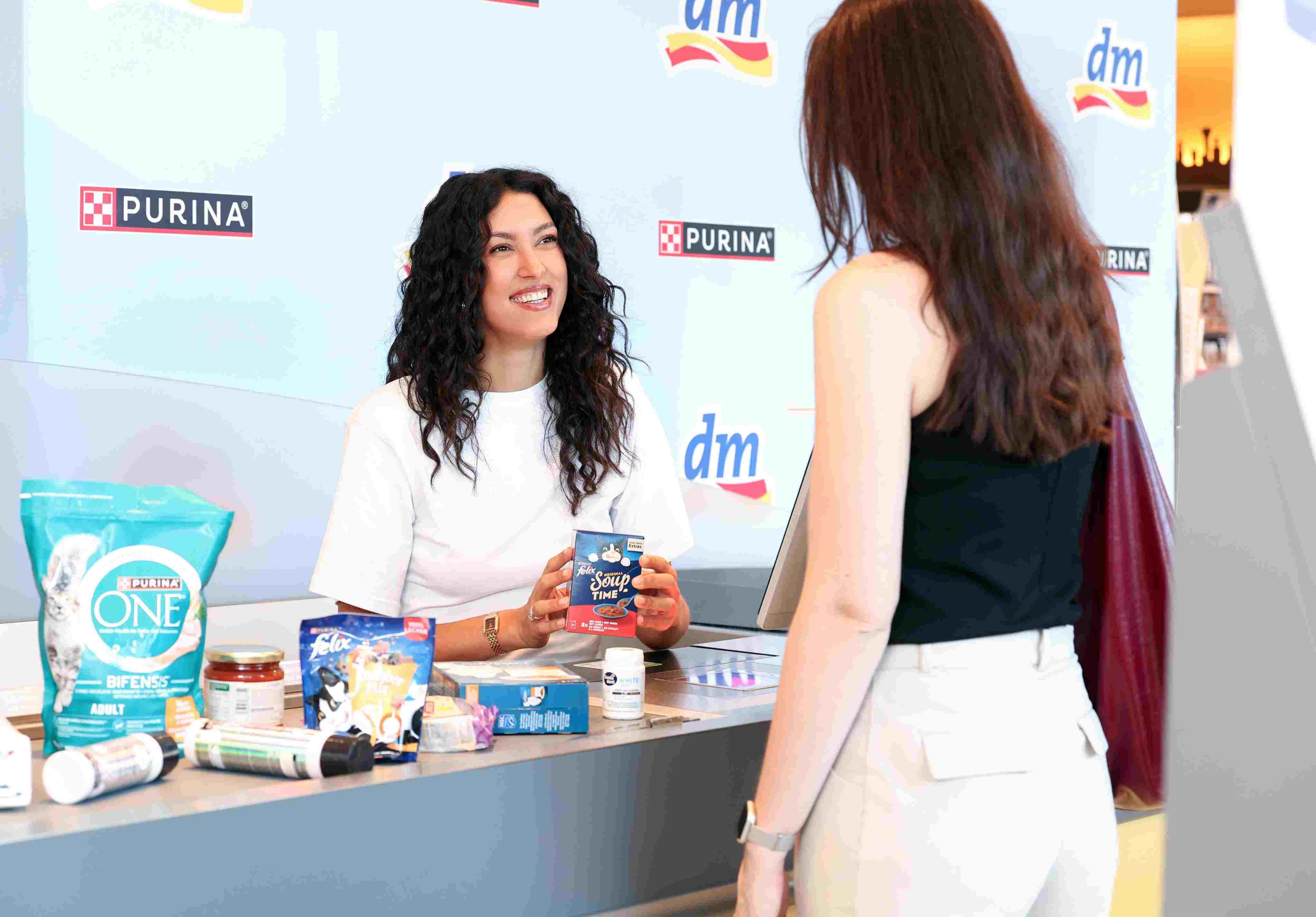Rebecca Mir bei dm an der Kasse