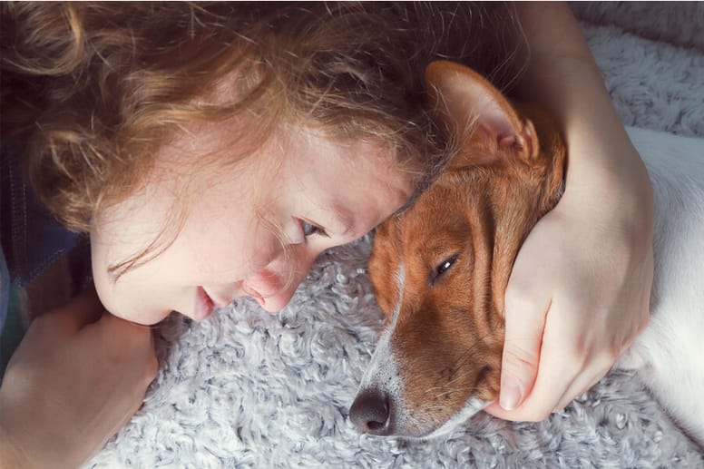 mujer abraza a su perro enfermo
