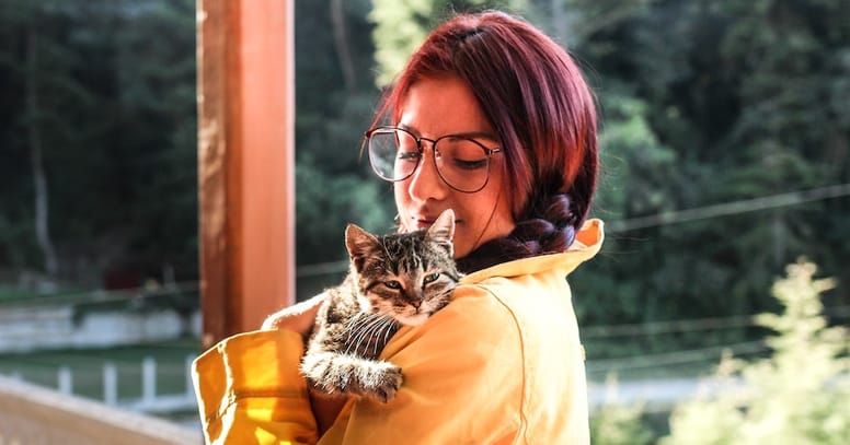 come dimostrare affetto al gatto: donna abbraccia gatto